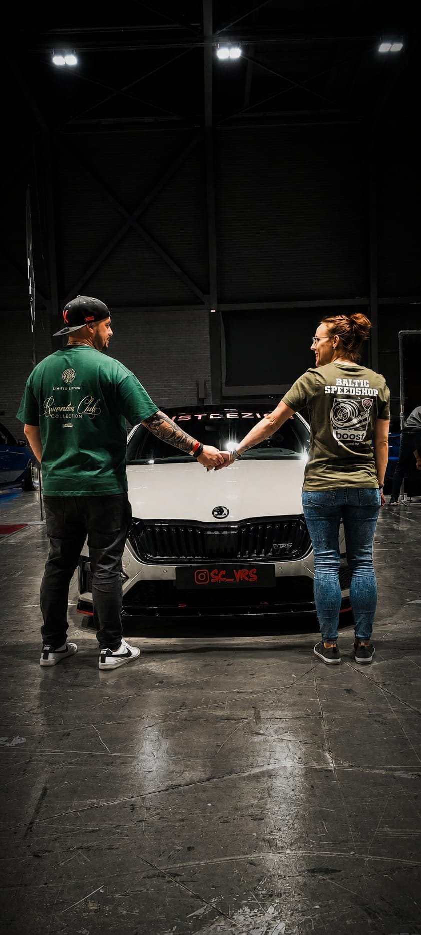 Sherin and Chris holding hands in front of their Škoda Octavia RS