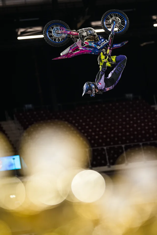 ZAPSA and his motocross bike upside down during an indoor freestyle performance